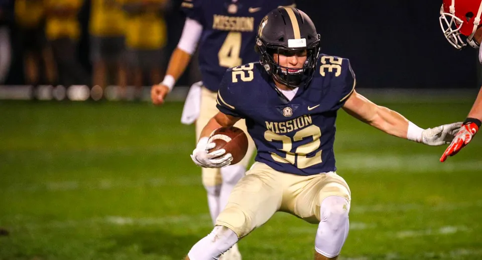 Un giocatore di football della Mission College Preparatory Catholic High School corre con la palla sul campo.