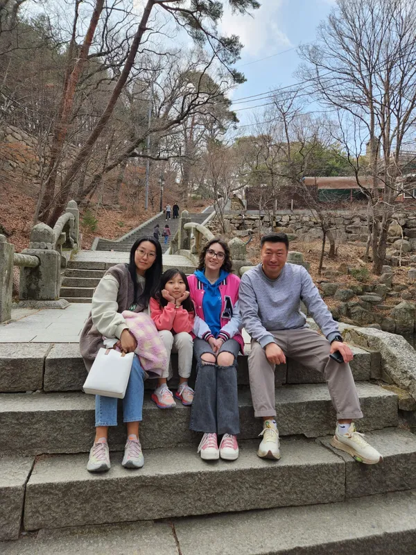 Studentessa con la famiglia ospitante su una scalinata in Corea del Sud