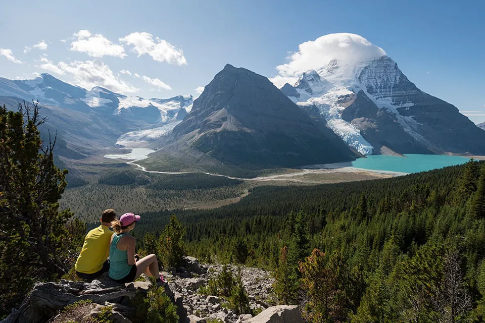 Due persone sono sedute su una roccia e si godono il paesaggio montano con lago vicino alla Valemount Secondary School.