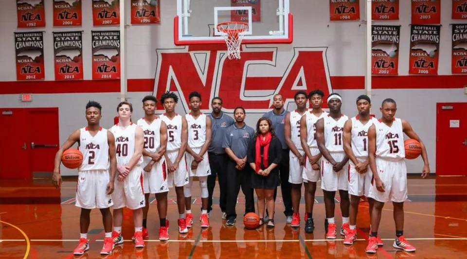 Studentesse della Northside Christian Academy posano sul campo da basket con il brand NCAA sullo sfondo.