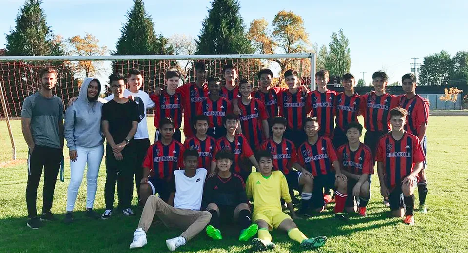 Un gruppo di studenti e studentesse della Sir Winston Churchill Secondary School posa insieme su un campo sportivo.
