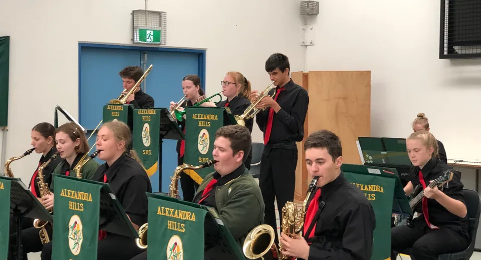 Un gruppo di musicisti della Alexandra Hills State High School si esibisce sul palco in divise coordinate.