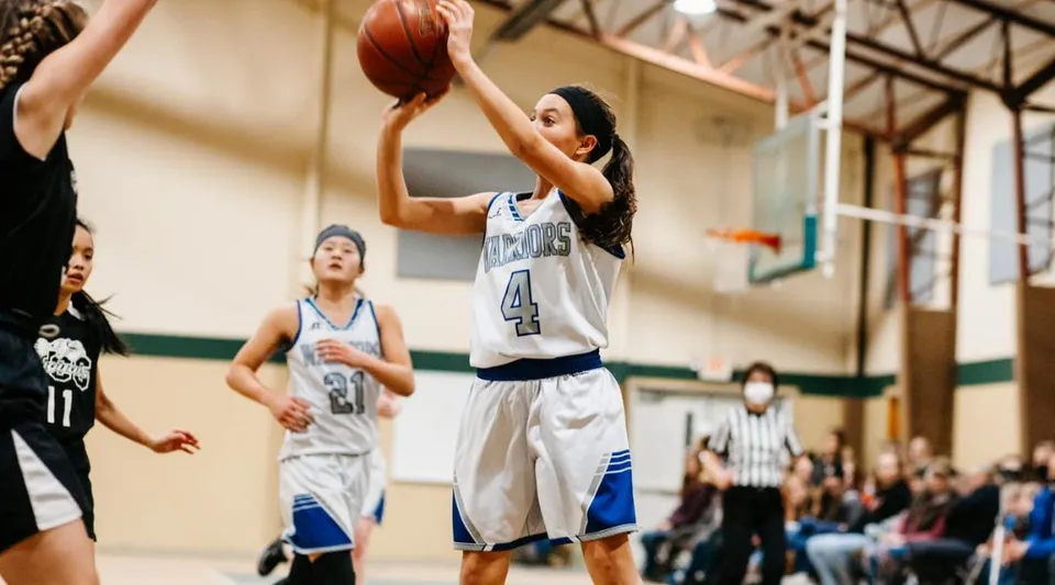 Una giocatrice di pallacanestro della Cambridge Christian School si prepara a tirare a canestro in una palestra.