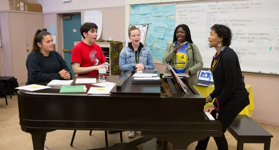 Studenti della H.B. Beal Secondary School suonano insieme il pianoforte in un'aula.