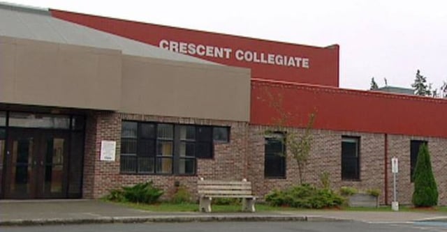 L'edificio rosso e bianco con la scritta Crescent Collegiate è circondato da un'area esterna ben curata con una panchina.
