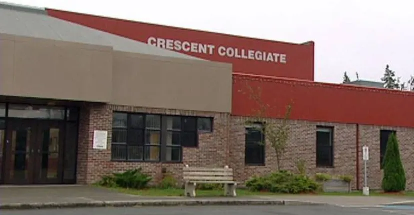 L'edificio rosso e bianco con la scritta Crescent Collegiate è circondato da un'area esterna ben curata con una panchina.