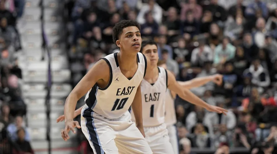 Un giocatore di basket della East Catholic High School si trova sul campo davanti a un grande pubblico.