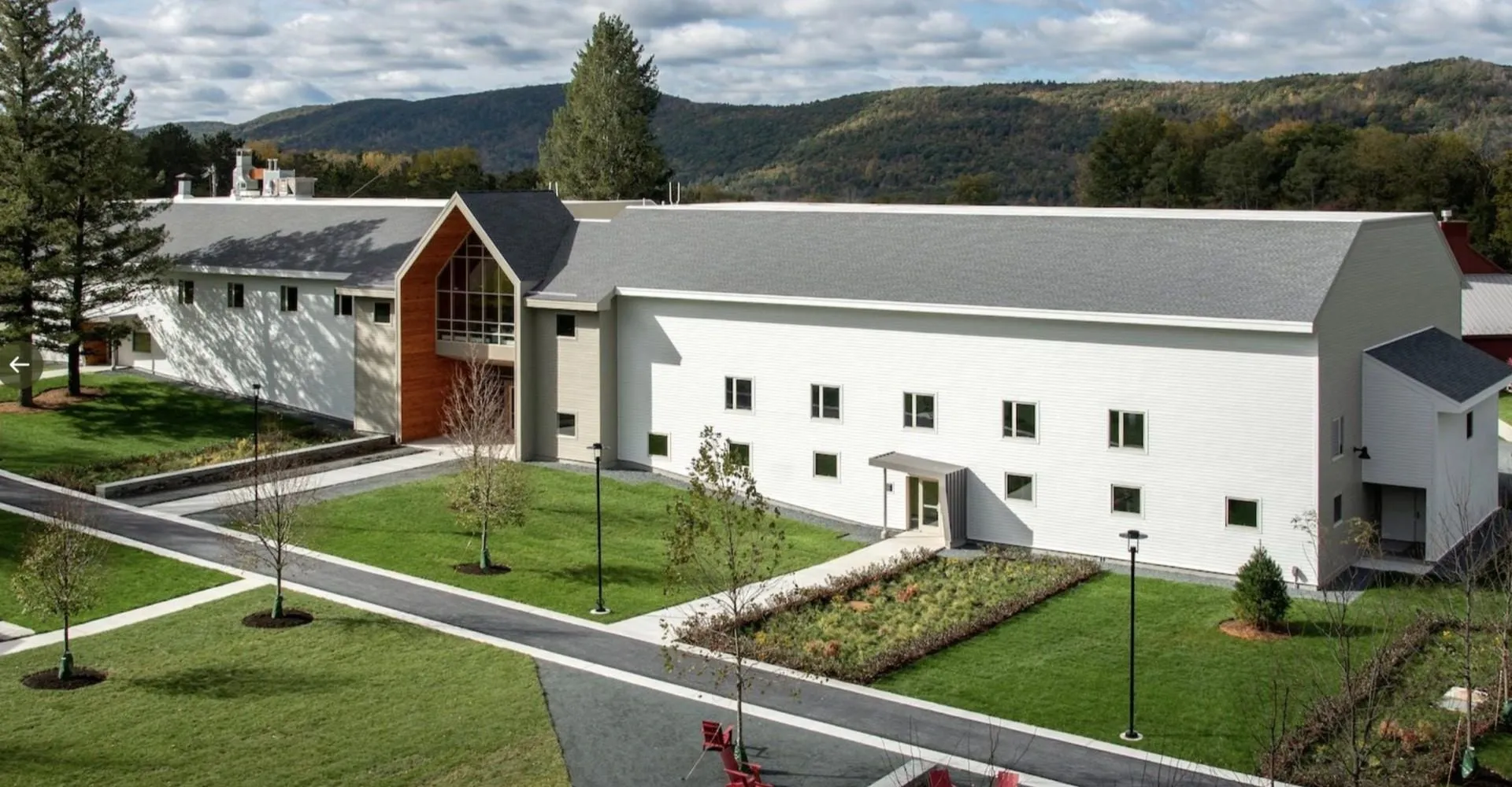 L'edificio bianco e moderno della Darrow School con un caratteristico arco in un ambiente curato e verdi colline sullo sfondo.