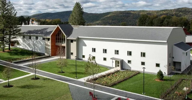 L'edificio bianco e moderno della Darrow School con un caratteristico arco in un ambiente curato e verdi colline sullo sfondo.
