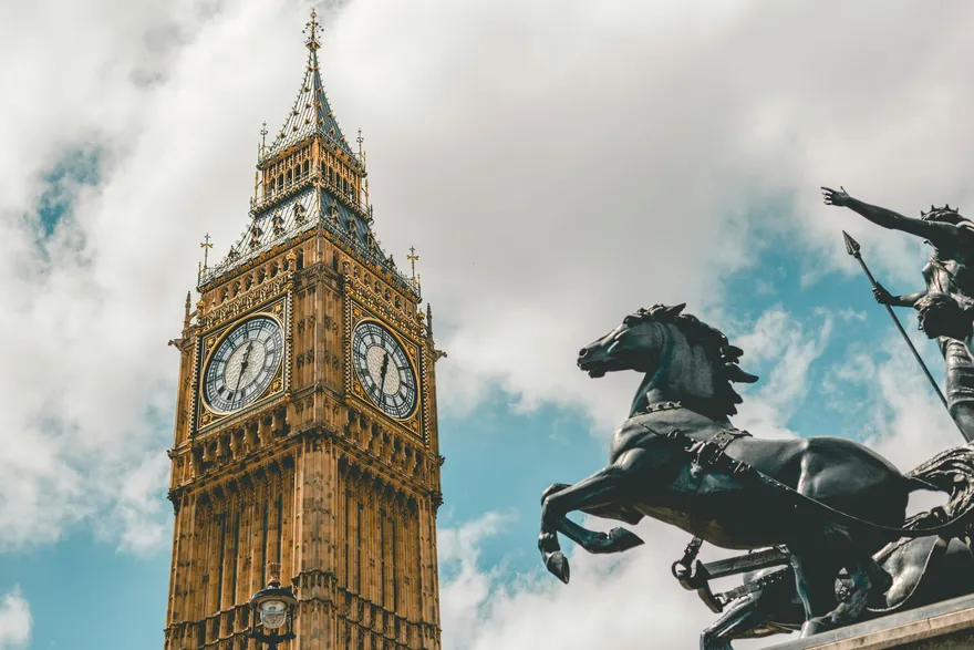 Il Big Ben e la statua di Boadicea a Londra visti dal basso contro un cielo carico di nuvole