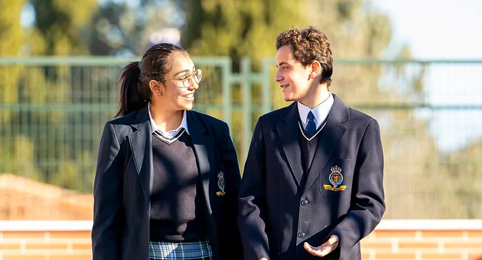 Due studenti in uniforme scolastica conversano nell'area esterna del King's College.