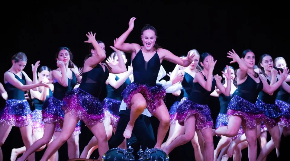 Un gruppo di ballerine si esibisce sul palco in una scena presso la Endeavour Sports High School.