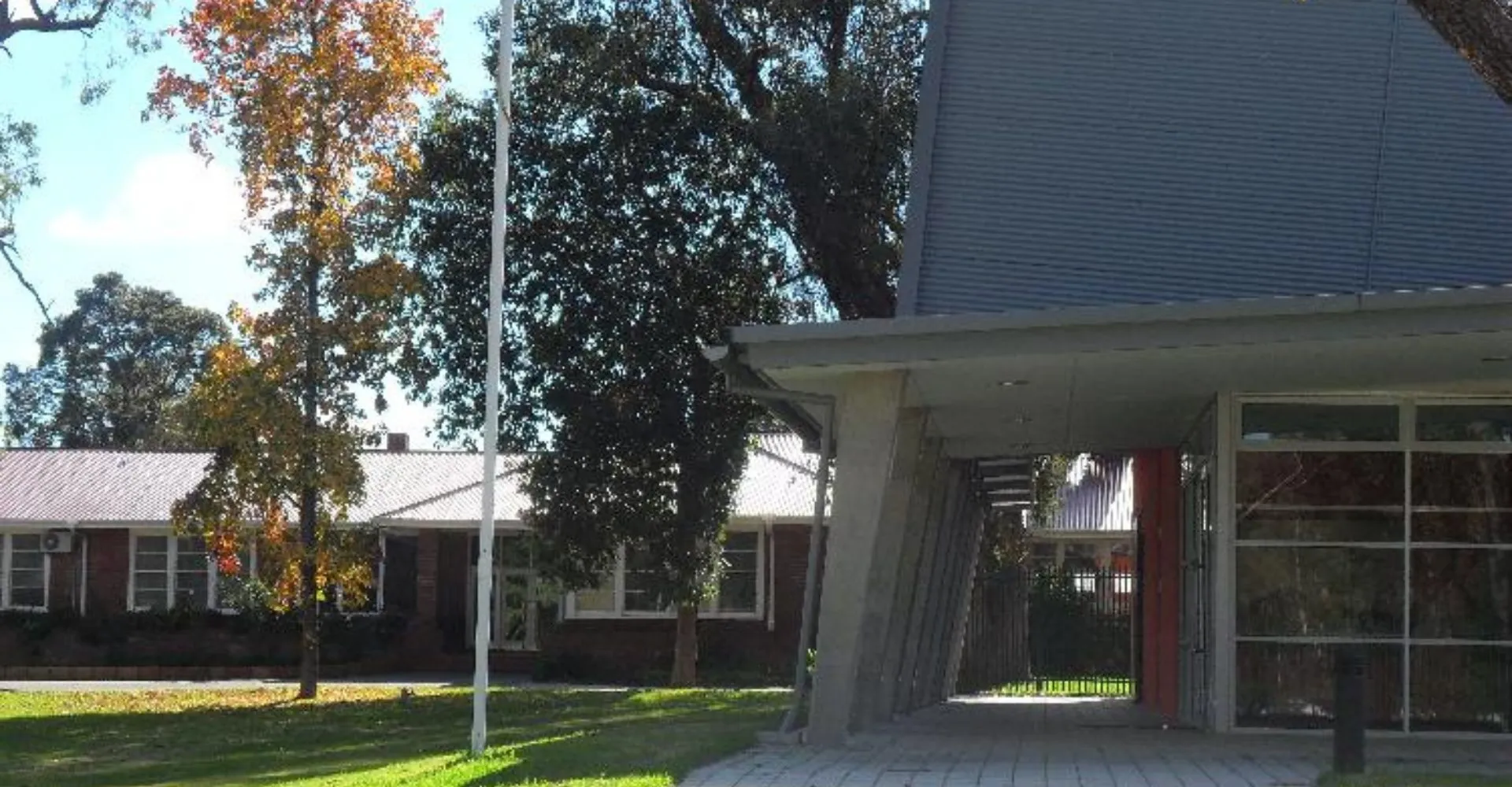 L'edificio residenziale con ingresso coperto si trova nel campus della Eastern Hills Senior High School ed è circondato da alberi.