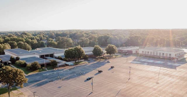 Ein großer offener Parkplatz mit Bäumen und Schulgebäuden im Hintergrund auf dem Gelände der Northpoint Christian School.