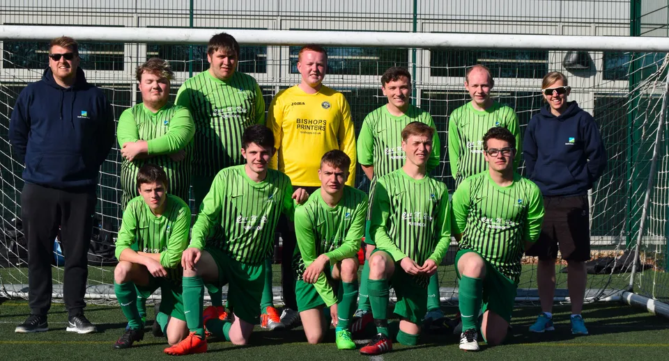 Un gruppo di calciatrici e calciatori del South Downs College posa insieme sul campo da calcio.