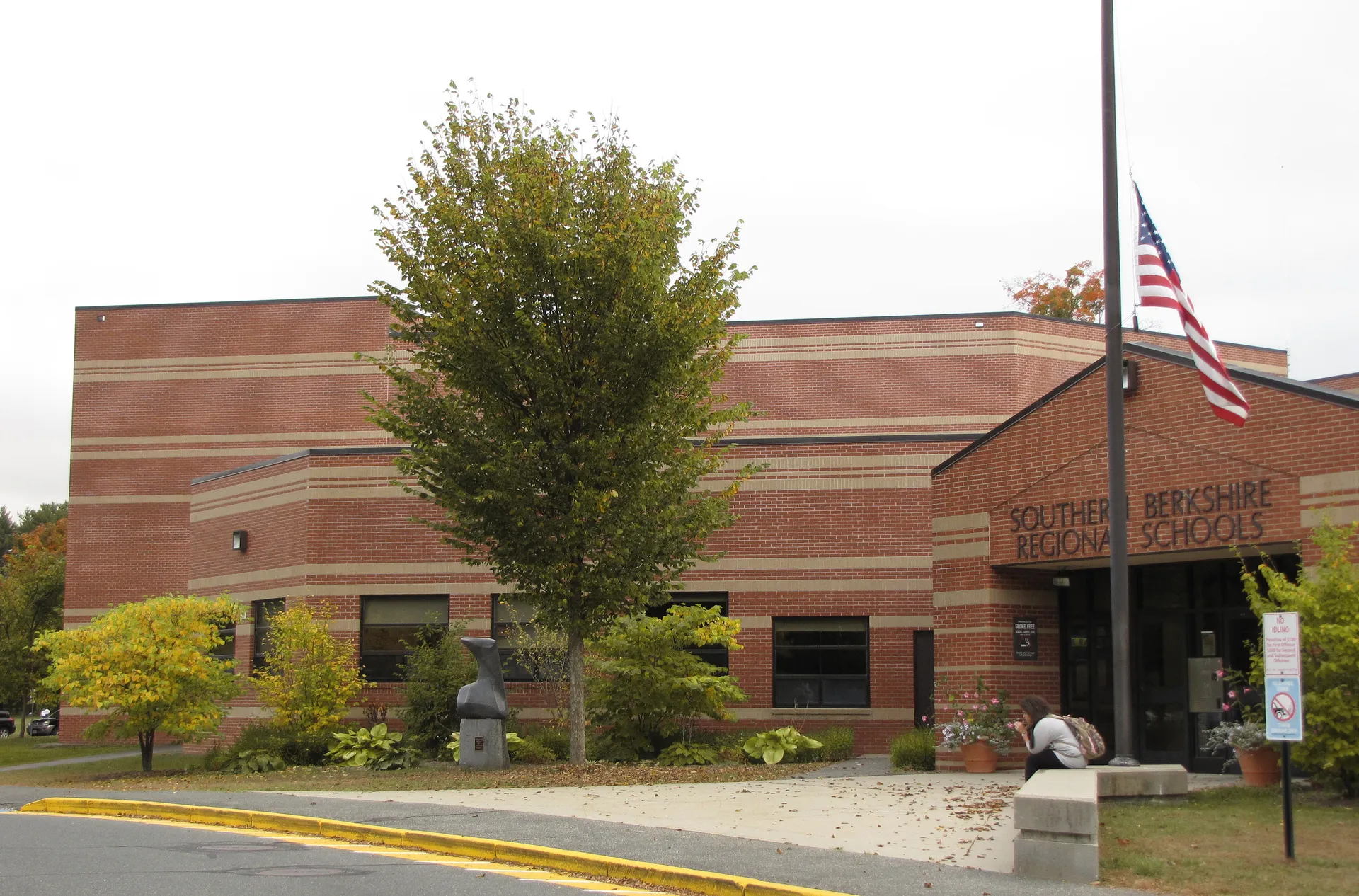 L'edificio in mattoni della Mount Everett Regional High School con una bandiera americana e studenti all'ingresso.