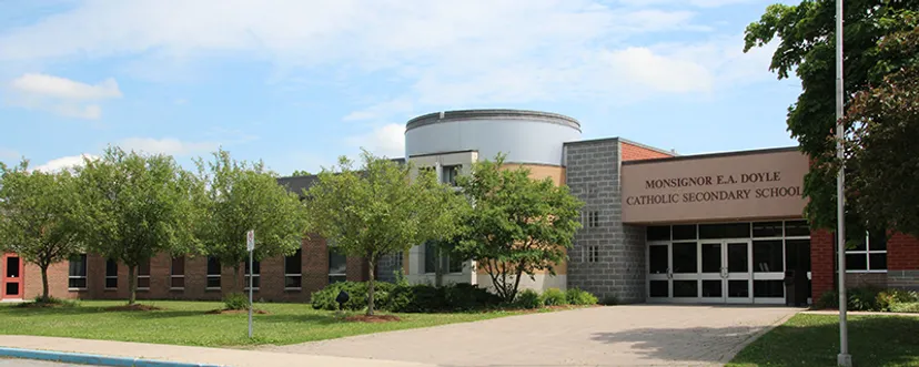 Il moderno edificio scolastico della Monsignor Doyle Catholic Secondary School con struttura circolare si trova circondato da un prato ben curato e da un verde paesaggio.