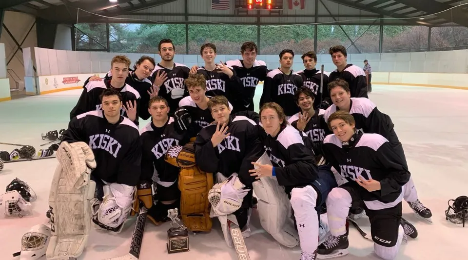 Un gruppo di studenti della The Kiski School posa in uniformi da hockey sulla pista di ghiaccio.