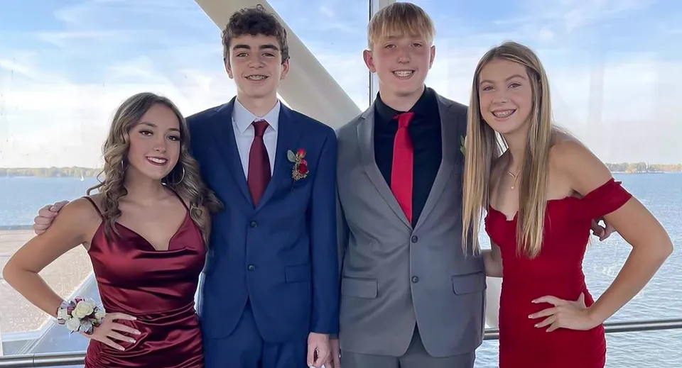 Quattro studenti della Mercyhurst Prep School posano insieme su una barca con l'acqua e il cielo sullo sfondo.