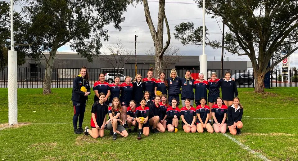 Un gruppo di giovani atlete in posa su un campo d'erba nel campus del Charles Campbell College.