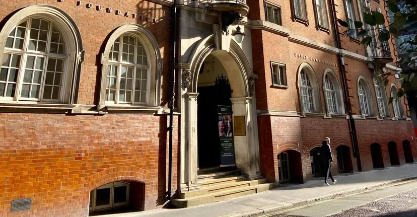 L'edificio storico in mattoni del David Game College Liverpool con finestre ad arco e un portone d'ingresso finemente decorato.