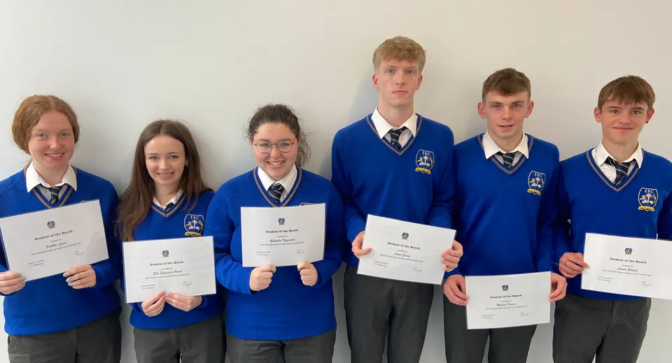 Studenti dell'Edmund Rice College in divisa scolastica tengono certificati davanti a uno sfondo bianco.