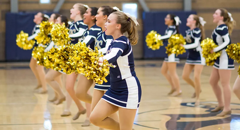 Un gruppo di cheerleader si trova con pompon gialli nella palestra della Rancho Solano Preparatory School.