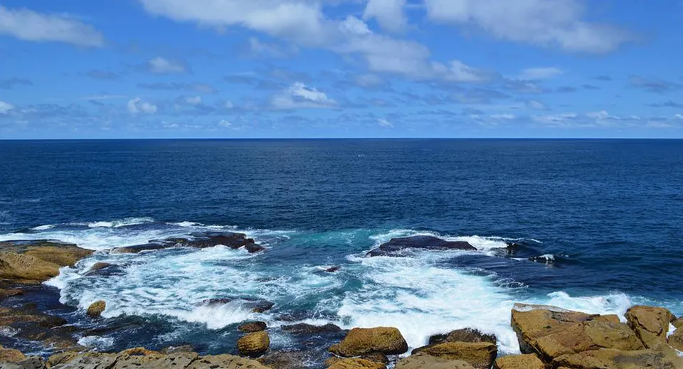 La costa con scogliere rocciose e l'oceano blu profondo sullo sfondo, vicino alla Aspley State High School.