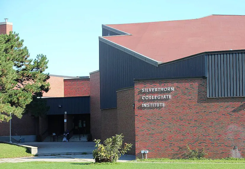 L'edificio moderno del Silverthorn Collegiate Institute con facciata in mattoni e metallo è circondato da alberi.