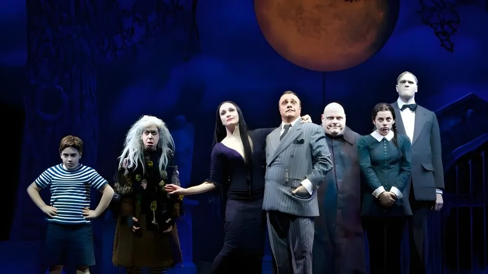 Studenti della D.P. Todd Secondary School in costumi della Famiglia Addams su un palco teatrale.
