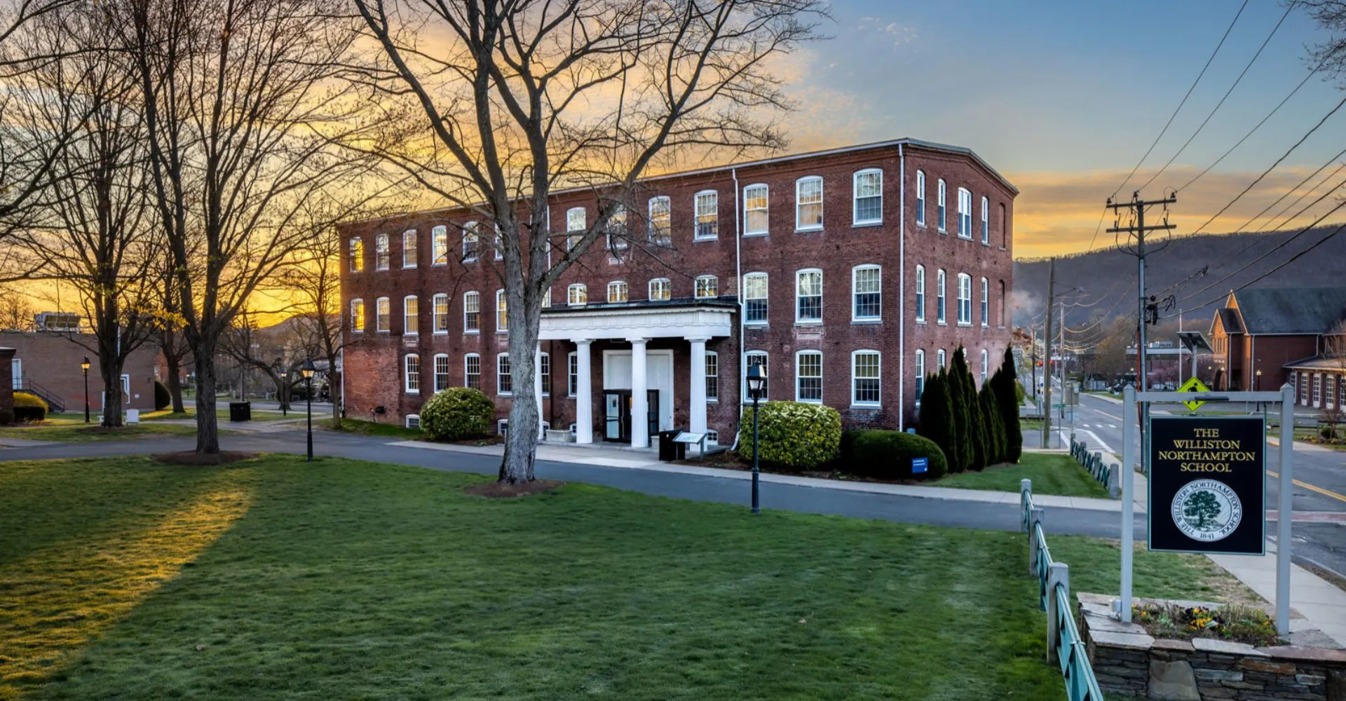 L'edificio in mattoni della The Williston Northampton School con un portico a colonne e un cartello sul campus.