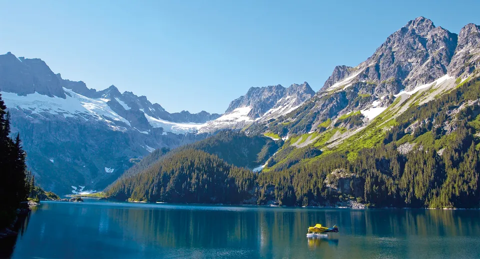 Una piccola barca galleggia sul lago calmo tra le montagne vicino alla Sparwood Secondary School.