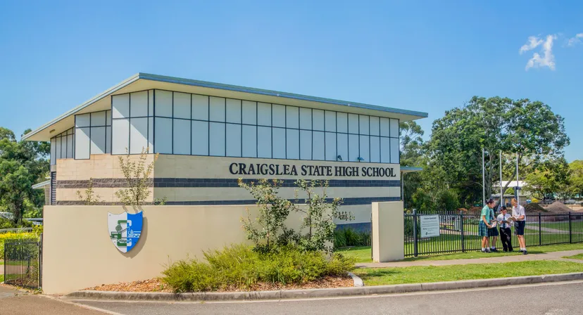 L'edificio scolastico moderno e a più piani della Craigslea State High School è circondato da alberi e aree verdi.