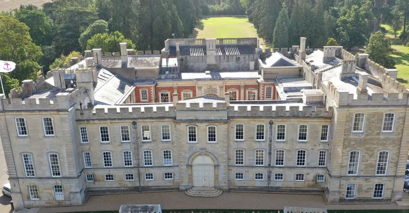 Vista aerea dello storico edificio principale della Kimbolton School con cortile interno e alberi.
