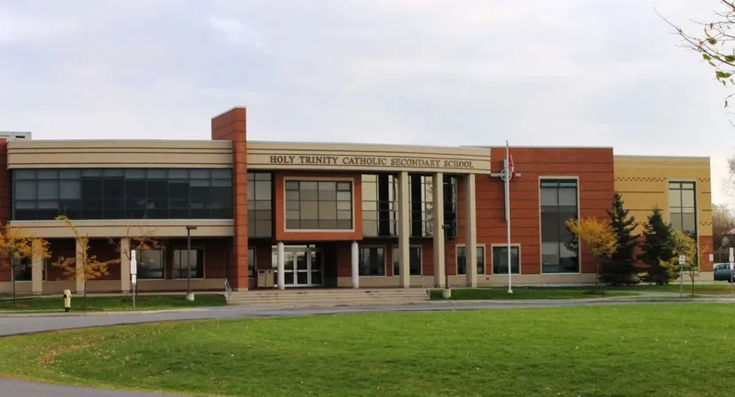 L'edificio moderno in mattoni della Holy Trinity Catholic High School è circondato da prato e alberi.