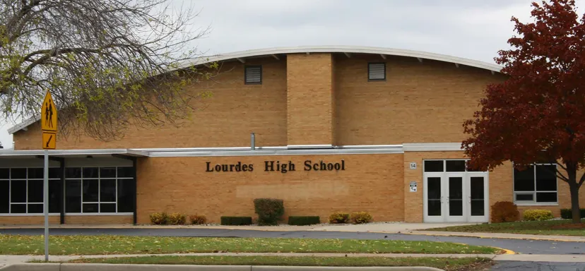 L'edificio in mattoni della Lourdes Academy è circondato da alberi e da un'area verde.