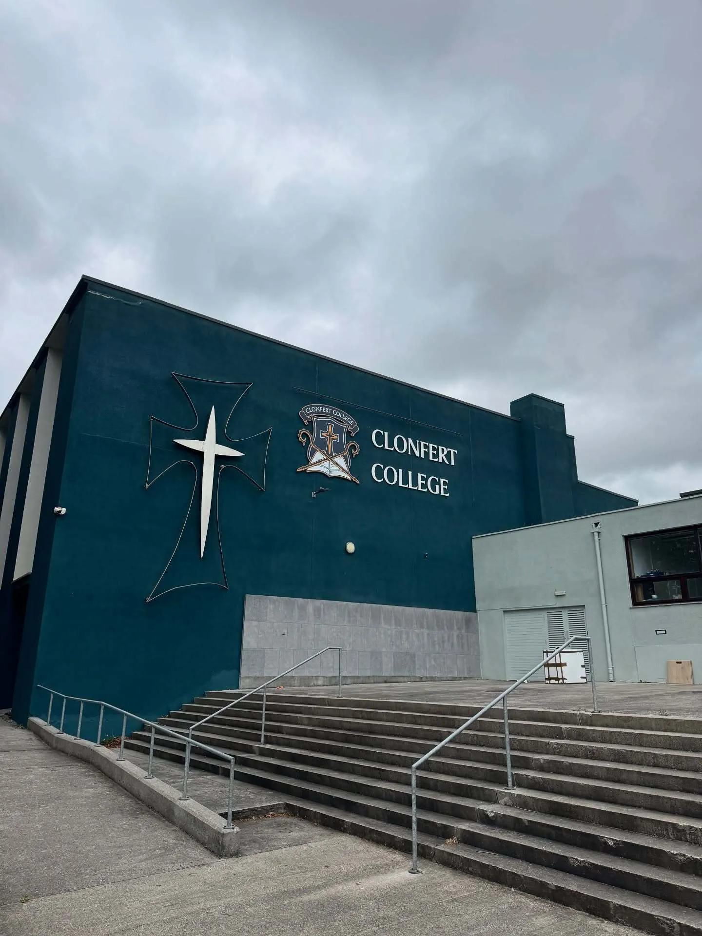 El Clonfert College muestra un gran edificio verde oscuro con una cruz llamativa en la fachada.
