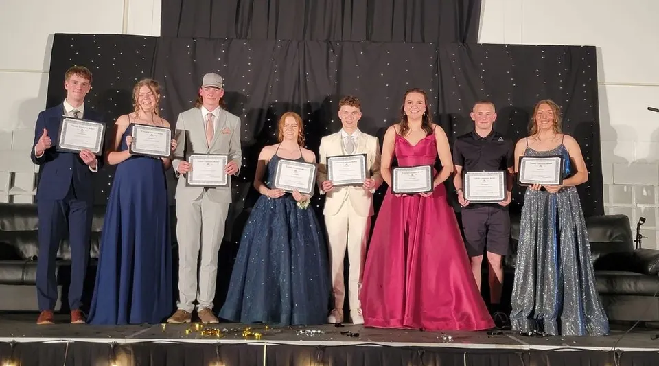Studenti della Lomond Community School stanno sul palco e mostrano dei riconoscimenti davanti a un cielo stellato.