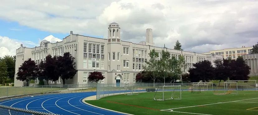 L'imponente edificio della Point Grey Secondary School con la torre dell'orologio si trova dietro il campo sportivo con pista di atletica e porte da calcio.