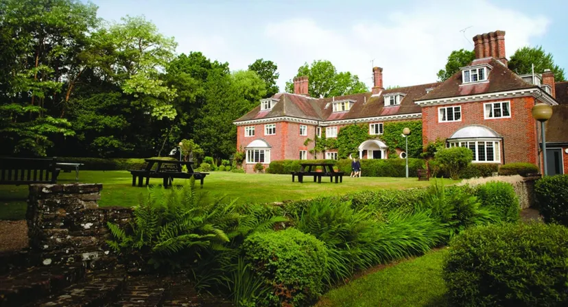 L'edificio in mattoni rossi della Luckley House School è circondato da un rigoglioso giardino con grandi alberi.
