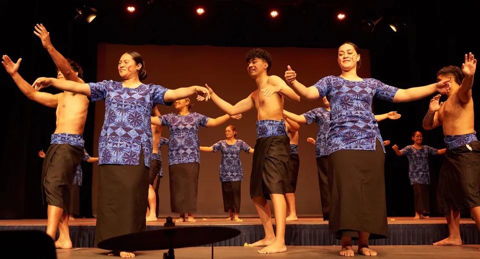 Gli studenti del Saint Kentigern College si esibiscono sul palco in uno spettacolo di danza indossando magliette e pantaloncini a motivi colorati.