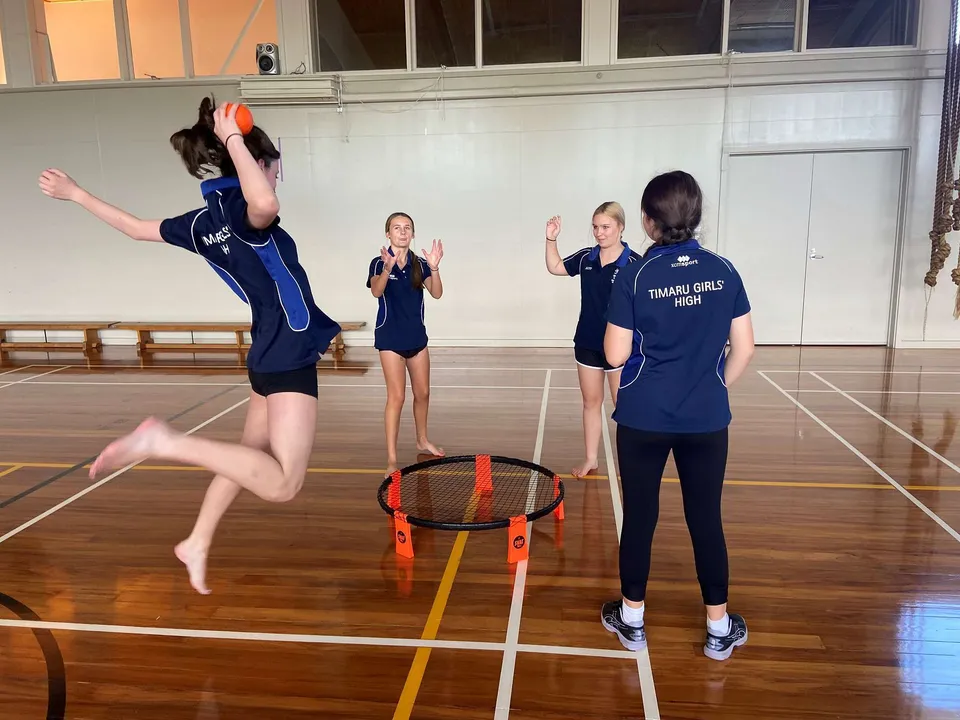 Studentesse della Timaru Girls School si esercitano a pallavolo in palestra.
