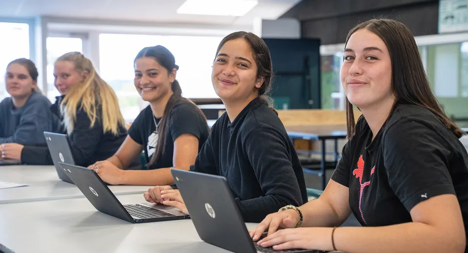 Un gruppo di studentesse della Kamo High School lavora concentrato ai laptop in un'aula moderna.