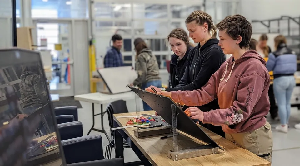 Un gruppo di studenti è in piedi davanti ai monitor dei computer durante le lezioni al Camosun College.