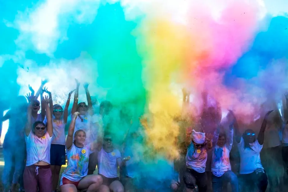 Gli studenti della Indian River Charter High School festeggiano con polvere colorata durante un evento festivo.