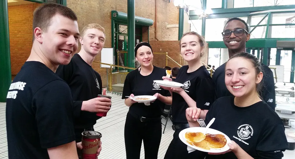 Gli studenti del Centre High Campus si godono insieme una pausa con snack nell'area esterna davanti a un edificio in mattoni.