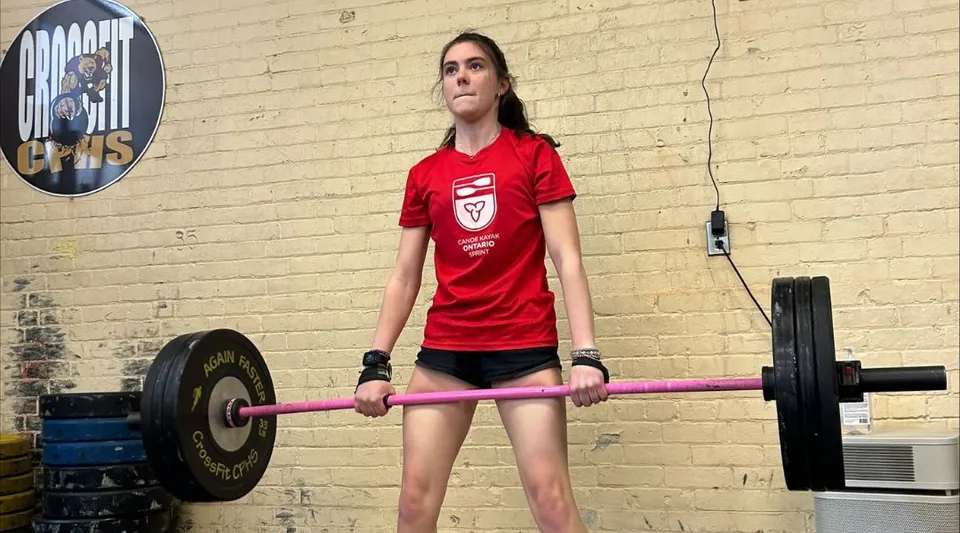 Una studentessa della Carleton Place High School si allena con un manubrio in palestra.