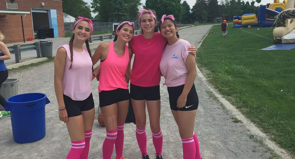 Un gruppo di giovani studentesse della Banting Memorial High School si trova all'aperto su un campo sportivo.