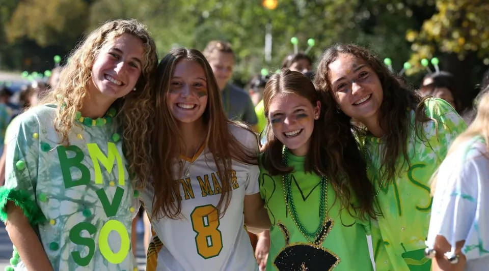 Un gruppo di studentesse della Bryn Mawr School si trova all'aperto davanti ad alberi e aree verdi.