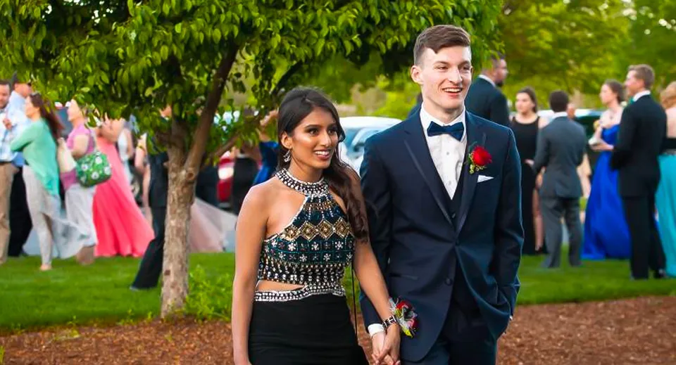 Una giovane coppia in abito formale si trova a un evento nell'area esterna della Bishop Brady High School.